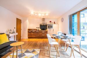 a living room with a table and chairs and a kitchen at Stylish 2 Bed City Centre Apartment with Sofa Bed - FREE Parking, Espresso Machine, Netflix, Alexa in Sheffield