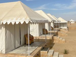 a row of white tents in the desert at Heritage Luxury Camp in Sām