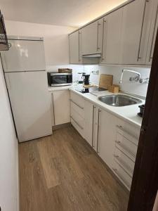 シエラネバダにあるS.N. The Holiday. Sol Y Nieve.の白いキャビネットとシンクを備えた小さなキッチン +12枚の写真