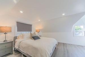 a white bedroom with a bed and a window at Niagara Property in Niagara Falls