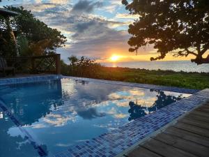 einen Pool mit Sonnenuntergang im Hintergrund in der Unterkunft Cocolobo Resort in West End