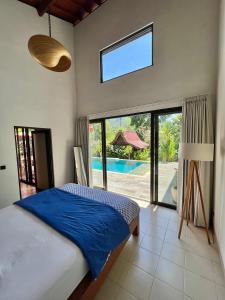 a bedroom with a bed and a view of a pool at Graha Ayoe in Sidemen