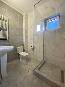 y baño con ducha, aseo y lavamanos. en Hotel Stadion en Oradea