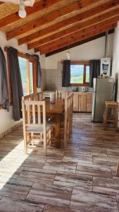 Cabaña SANTA MONTAÑA في أوشوايا: مطبخ مع طاولة وكراسي خشبية في الغرفة