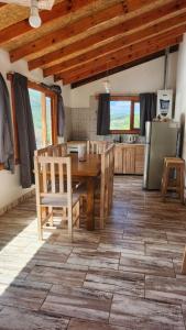 a kitchen with a wooden table and chairs in a room at Cabañas SANTA MONTAÑA in Ushuaia