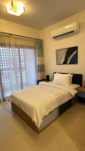 een slaapkamer met een groot bed en een raam bij City Gem - Qurm in Muscat