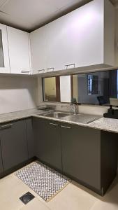 a kitchen with white cabinets and a sink at City Gem - Qurm in Muscat