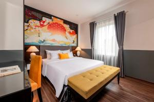 a bedroom with a large bed and a painting on the wall at Hanoi Elpis Hotel & Spa in Hanoi