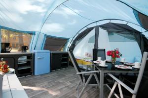 a tent with a table and a kitchen in it at Luxuswohnzelt ZELT UND SAND direkt am Strand in Dranske