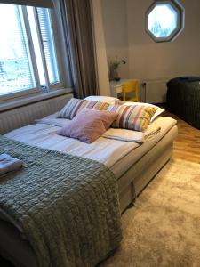 a large bed with pillows on it in a bedroom at Cosy apartment in the city center in Kemi