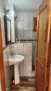 uma casa de banho com um lavatório e um espelho em Cabaña SANTA MONTAÑA em Ushuaia