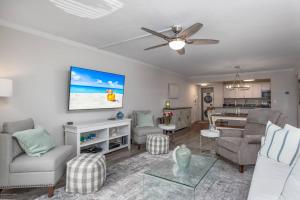 uma sala de estar com uma televisão de ecrã plano na parede em Harbor Towers End Unit, 4th Fl Pool & Bay Views em Siesta Key
