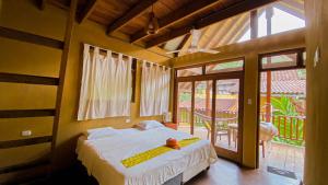 1 dormitorio con cama y ventana grande en Canto del Río Lodge en Tarapoto