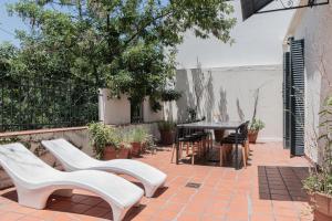 un patio con sillas blancas y una mesa en Fliphaus Soria 5100 - 4 Bd Pool Bbq Soho en Buenos Aires