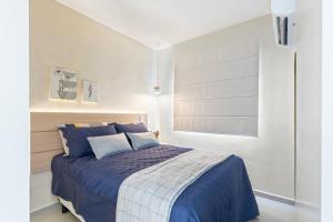 1 dormitorio con cama con sábanas azules y ventana en Apartamento em São José dos Campos, en São José dos Campos