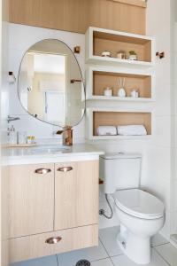 y baño con aseo y espejo. en Apartamento em São José dos Campos, en São José dos Campos
