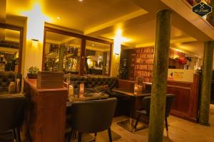 a restaurant with a table and chairs and a bar at Hotel Malon in Leuven
