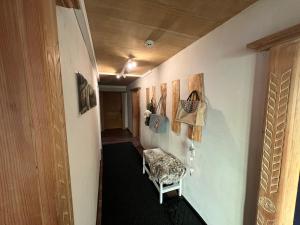 a hallway with a chair and paintings on the wall at Beim Patzelt - Ferienhaus in Nesselwang in Nesselwang