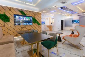 a lobby with a table and chairs and a tv on a wall at God's Touch Apartments Remi Fani Kayode GRA. Ikeja in Ikeja