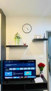 a tv sitting on a shelf with a clock on the wall at The base Central Pattaya 271 by Numam in Pattaya Central
