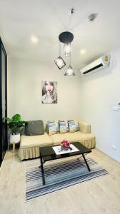 a living room with a couch and a table at The base Central Pattaya 271 by Numam in Pattaya Central