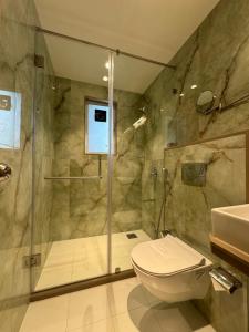 a bathroom with a shower and a toilet and a sink at Hotel Mumbai House, Malad in Mumbai