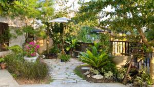 清萊的住宿－Cozy place @ Chiangrai，花园设有种有植物和遮阳伞的石道
