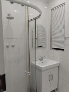 uma casa de banho branca com um chuveiro e um lavatório. em Inspire living home em Benoni