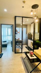 uma sala de estar com uma grande porta de vidro que leva a uma cozinha em The base Central Pattaya 271 by Numam em Pattaya Central