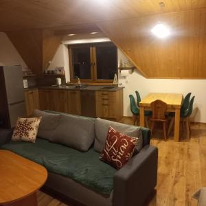 a living room with a couch and a kitchen at Tu i Teraz - domek in Bukowina Tatrzańska