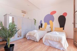 Habitación con 2 camas y una maceta. en Fliphaus Soria 5100 - 4 Bd Pool Bbq Soho en Buenos Aires