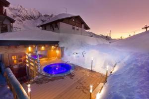 a building with a hot tub in the snow at La Torretta in Passo del Tonale