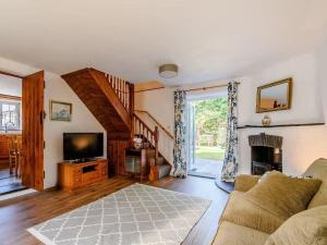 a living room with a couch and a television at The Gatehouse at Y Gwesty Bach in Jordanston