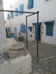 a building with blue and white walls and a pole at La maison 4 puits in Sidi Bou Saïd
