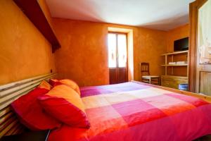 スコペッロにあるL'Ometto Bed&Breakfastのベッドルーム1室(大型ベッド1台、カラフルな毛布付)