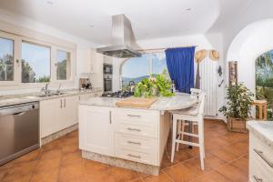 a kitchen with white cabinets and a large island at Casa Chilango in Montgo
