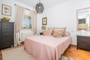 a bedroom with a bed with a pink blanket at Casa Chilango in Montgo
