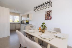 Il comprend une cuisine et une salle à manger avec une table et des chaises blanches. dans l'établissement Villa Valle Romano, à Estepona