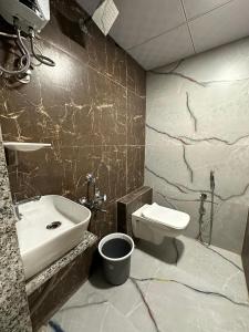 a bathroom with a sink and a toilet at Hotel sky palace adajan in Surat