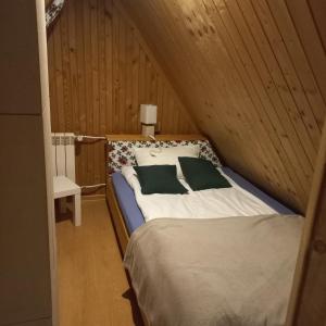 a bedroom with a bed in a wooden wall at Tu i Teraz - domek in Bukowina Tatrzańska