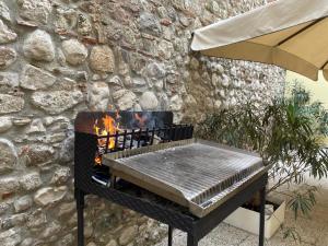 barbecue di fronte a un muro di pietra di Oasi Verde con Area Barbecue a Udine