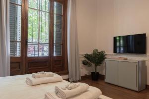 Habitación con TV y 2 toallas en una cama en Fliphaus Soria 5100 - 4 Bd Pool Bbq Soho en Buenos Aires