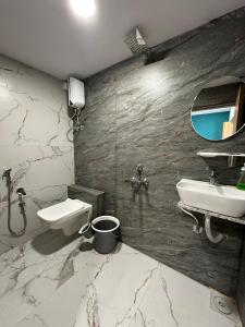 uma casa de banho com um lavatório, um WC e um espelho. em Hotel sky palace adajan em Surat