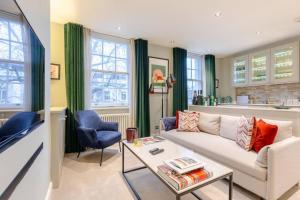 uma sala de estar com um sofá e uma mesa em Elegant 1BD Flat in the Heart of Notting Hill! em Londres