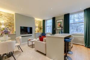 een woonkamer met een keuken en een woonkamer met een bank bij Elegant 1BD Flat in the Heart of Notting Hill! in Londen