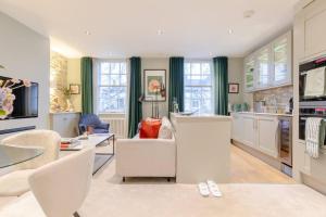 een keuken en een woonkamer met witte meubels bij Elegant 1BD Flat in the Heart of Notting Hill! in Londen