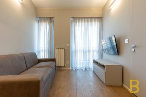 a living room with a couch and a flat screen tv at BePlace Apartments in Primaticcio in Milan