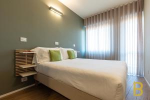 Un dormitorio con una cama grande y una ventana en BePlace Apartments in Primaticcio, en Milán