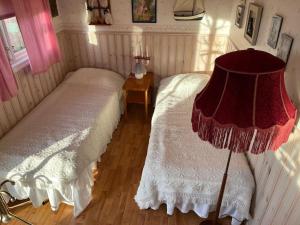 a bedroom with two beds and a lamp in it at Hallastugan in Karlskrona