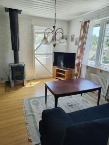 a living room with a coffee table and a fireplace at Hallastugan in Karlskrona